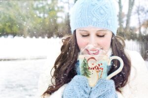 a woman holding a mug in the snow