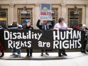 people holding sign that says "disability rights are human rights"