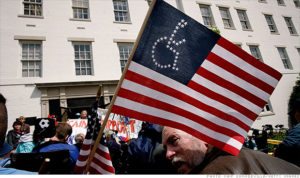 man holding american flag with stars arranged into wheelchair symbol